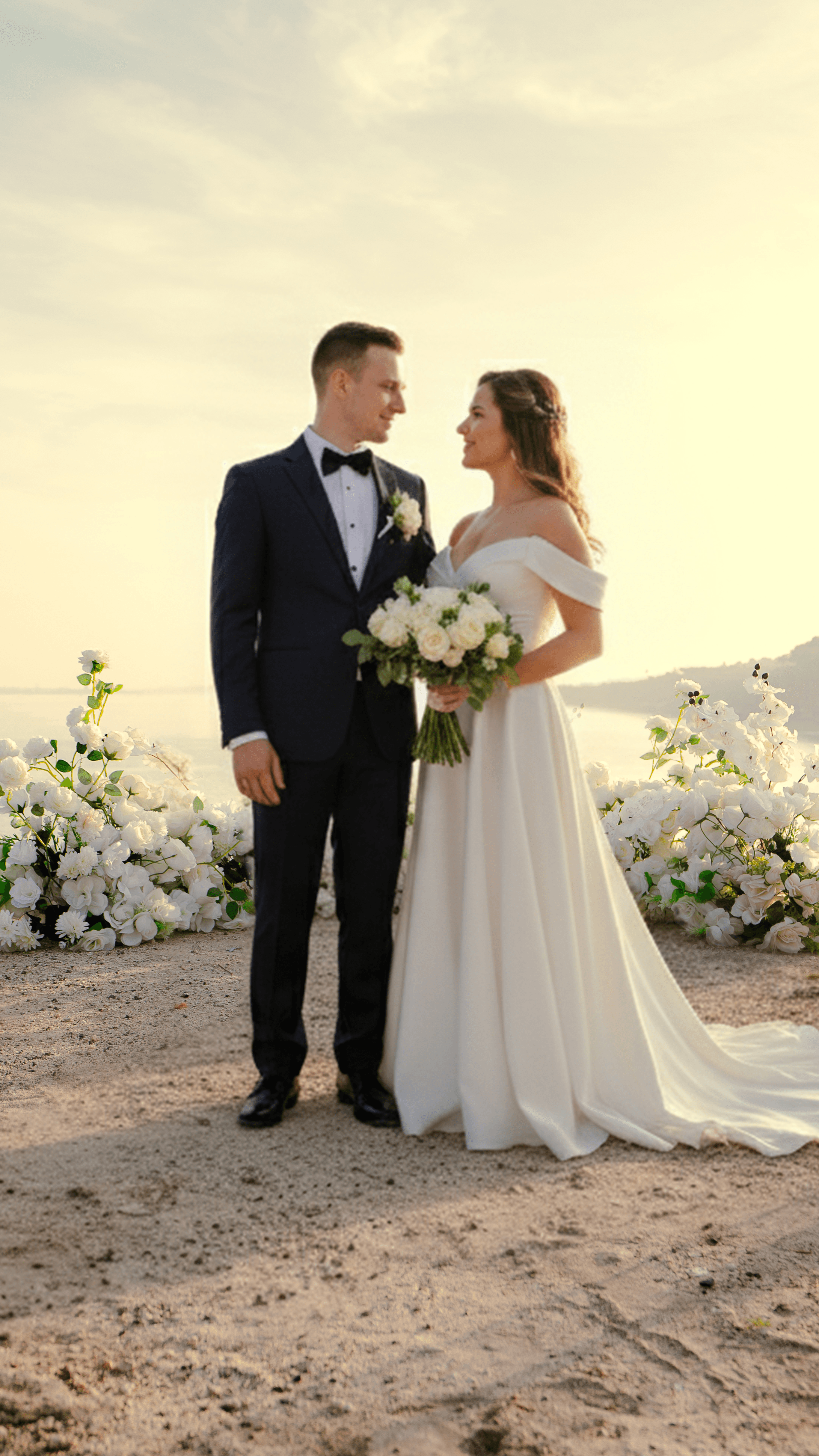 Couple embracing in field with flowing veil